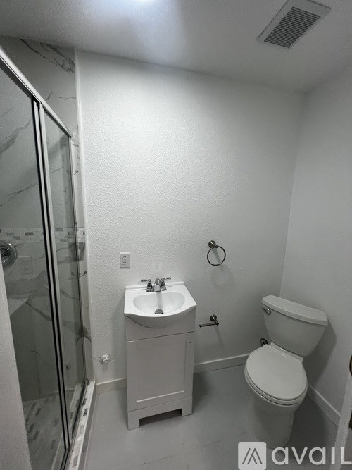 A bathroom with a toilet, sink, and shower.