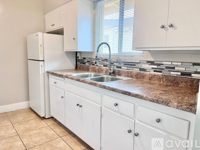 A kitchen with white cabinets and a granite countertop.