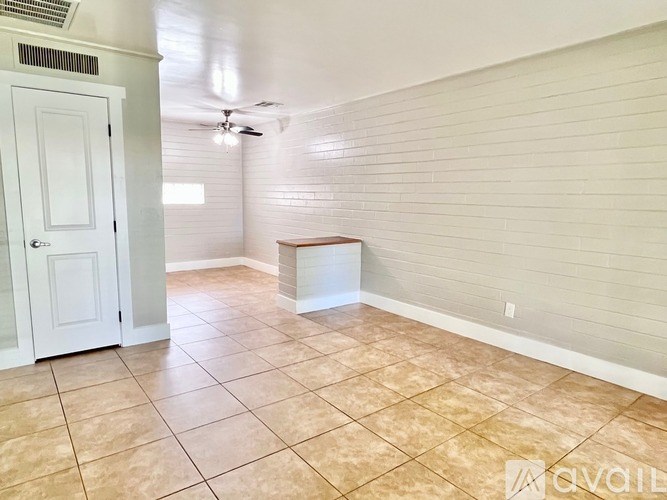 A room with a white door and a fan on the ceiling.
