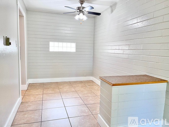 A room with a ceiling fan and a window.
