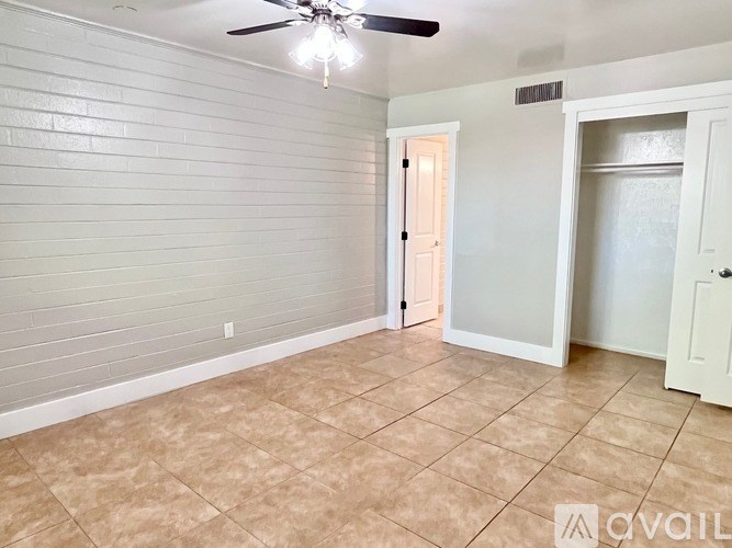 A room with a ceiling fan and tile flooring.