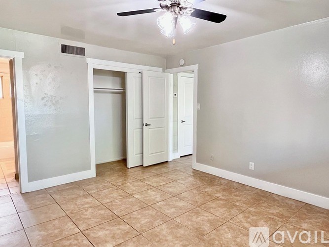 A room with a ceiling fan and tile flooring.