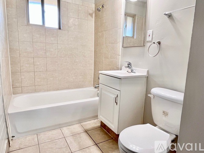 A white bathroom with a tub, toilet, and sink.