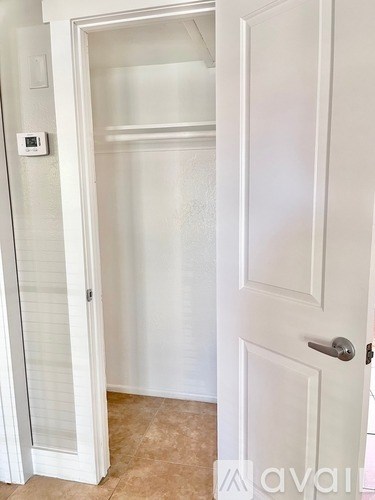 A white door with a silver handle is open.