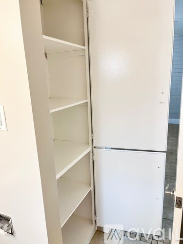 A white pantry cabinet with shelves is open.