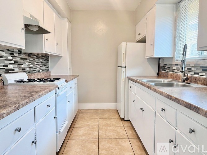 A kitchen with white cabinets and a granite countertop.