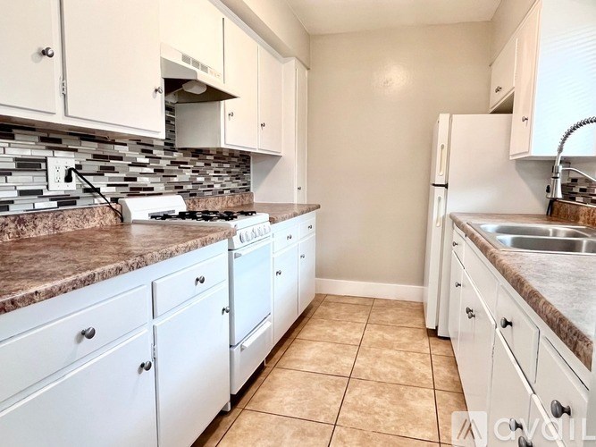 A kitchen with white cabinets and a granite countertop.