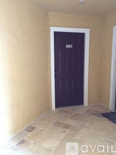 A dark brown door with the word "KITTE" written on it.