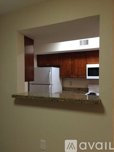 A kitchen with a refrigerator and microwave.