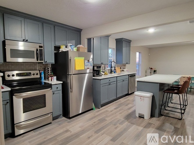 A kitchen with a refrigerator, oven, and microwave.