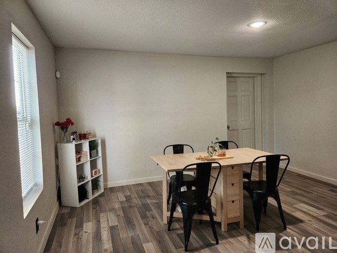 A dining room with a table, chairs, and a cabinet.