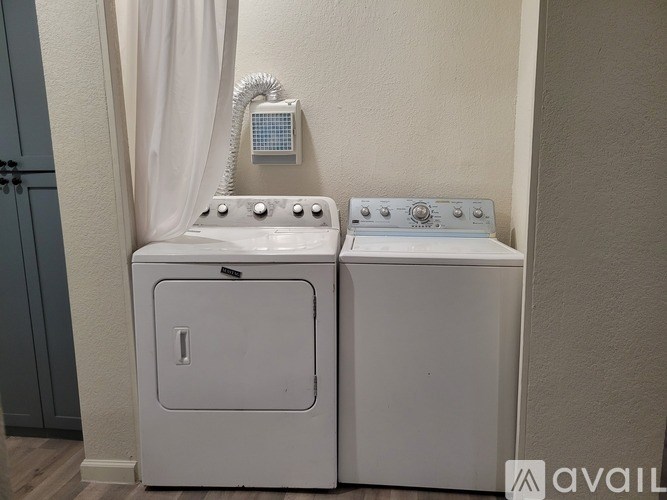Two white washing machines in a bathroom.