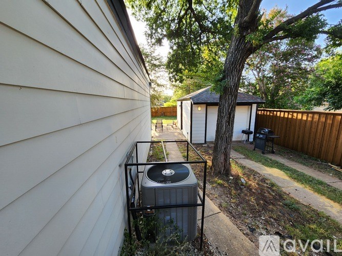 A wall with a window and a tree in front of a house.