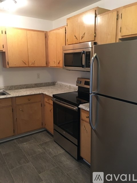 A kitchen with wooden cabinets and stainless steel appliances.