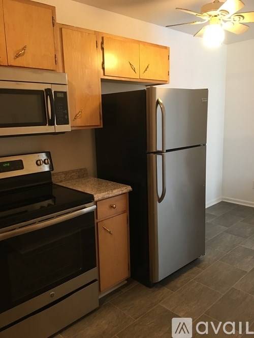 A kitchen with a black refrigerator and stainless steel appliances.