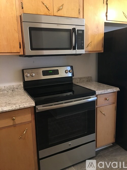 A kitchen with a stove, oven, and microwave.
