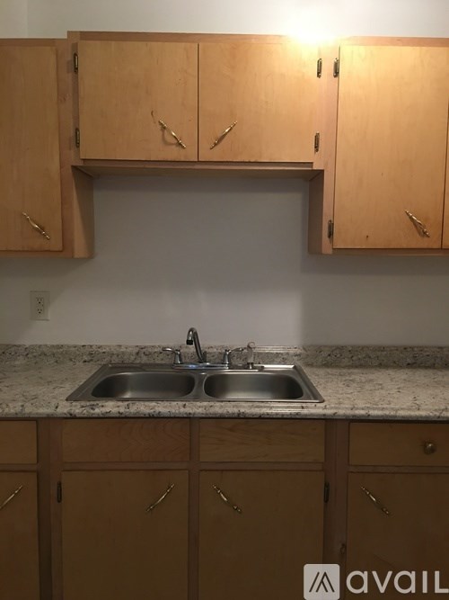 A kitchen with wooden cabinets and a granite countertop.