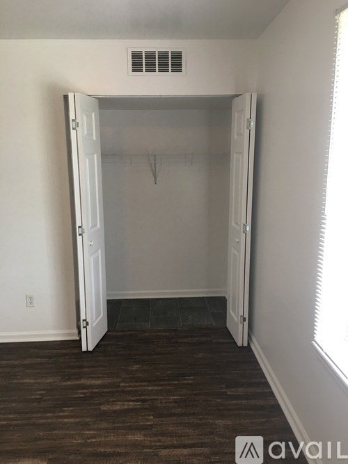 A room with a white door and a window with blinds.