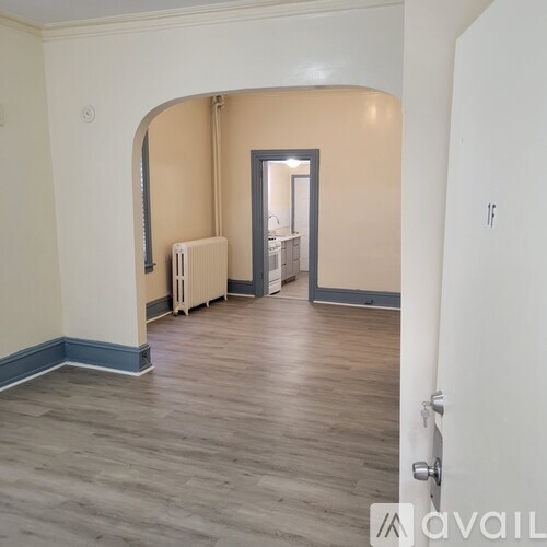 A room with a wooden floor and a white radiator.