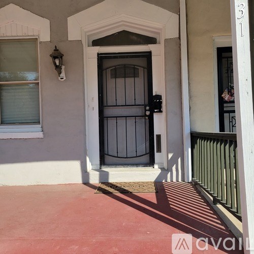 A black door with a white frame is on the right side of a white wall.