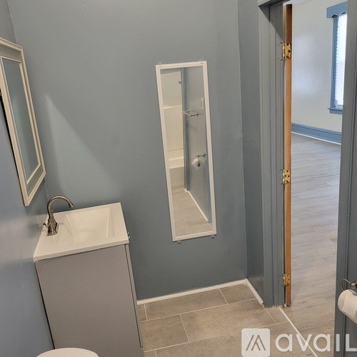 A bathroom with a toilet, sink, and a shower stall.