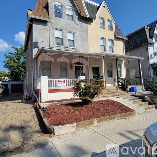 A two-story house with a red front door and a white porch.