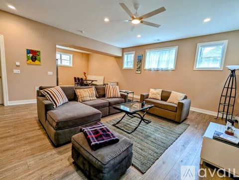 A living room with a brown sofa and a glass coffee table.