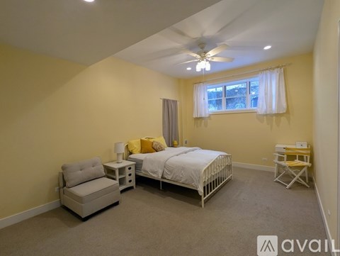 A bedroom with a bed, chair, and desk.