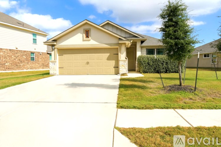 A house with a garage and a driveway in front of it.