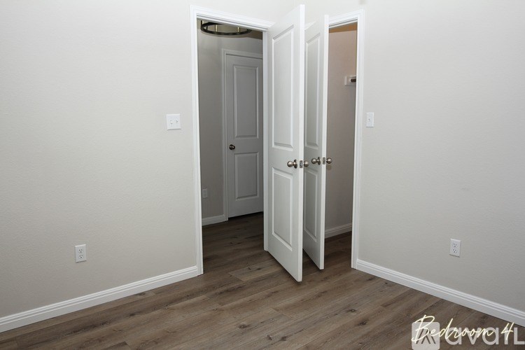 A room with a white door and a white wall.