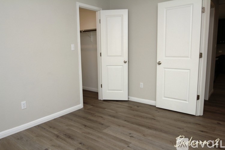 A room with two white doors and a wooden floor.