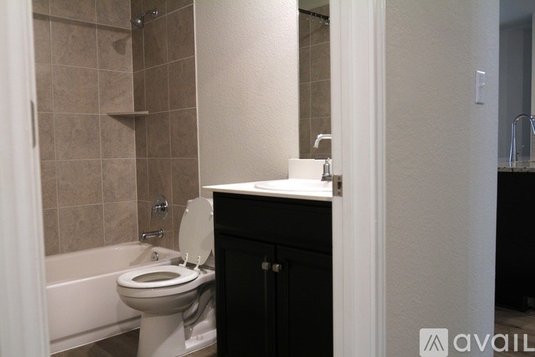 A bathroom with a toilet, a tub, and a cabinet.