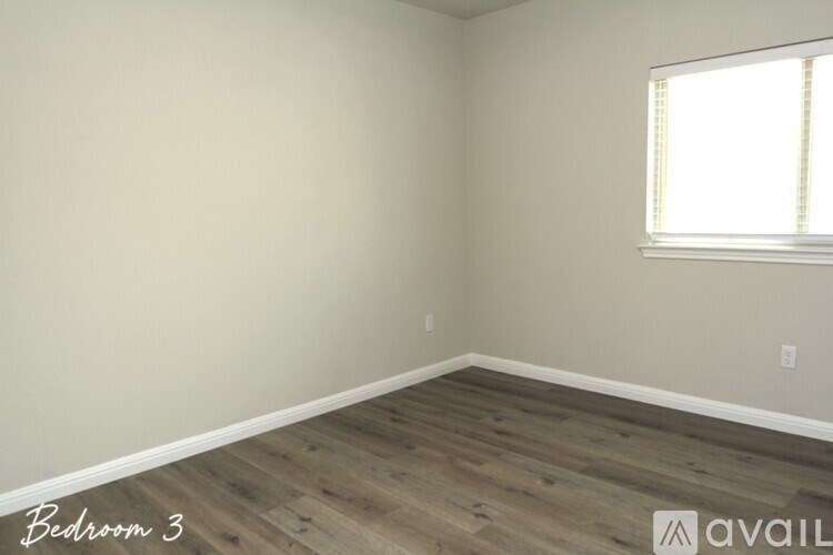 A room with wooden flooring and a window letting in light.