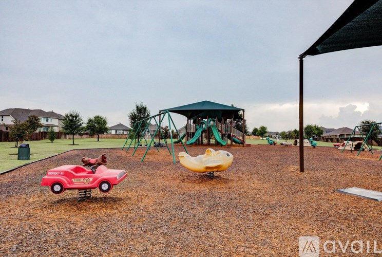 A playground with a red car and a yellow slide.
