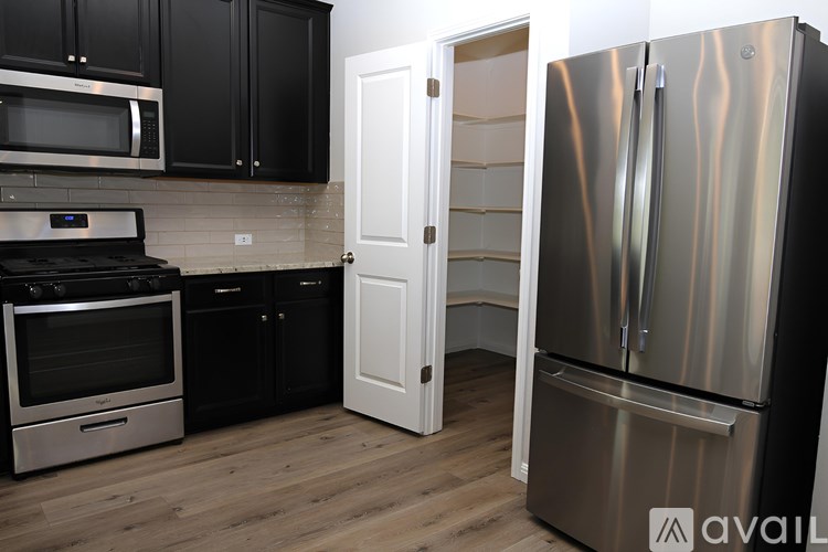 A kitchen with a stainless steel refrigerator, oven, and microwave.