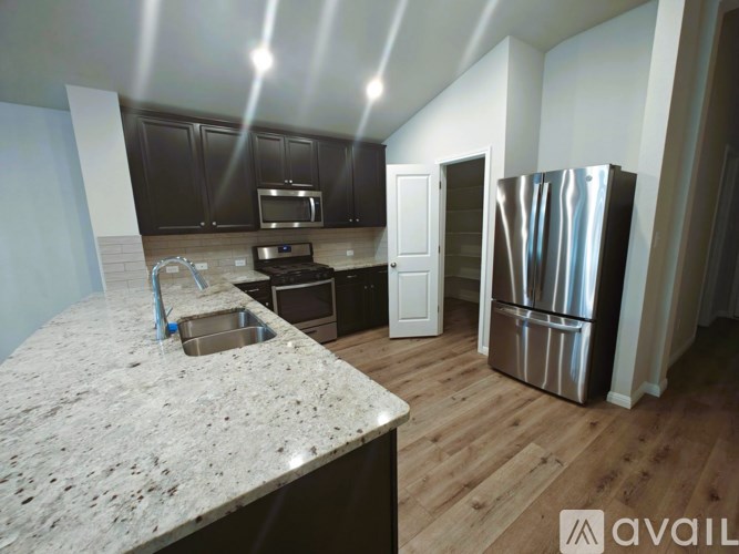 A kitchen with a granite countertop and stainless steel appliances.
