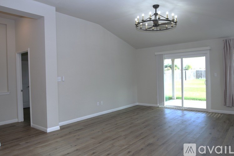 A room with wooden floors and a chandelier hanging from the ceiling.