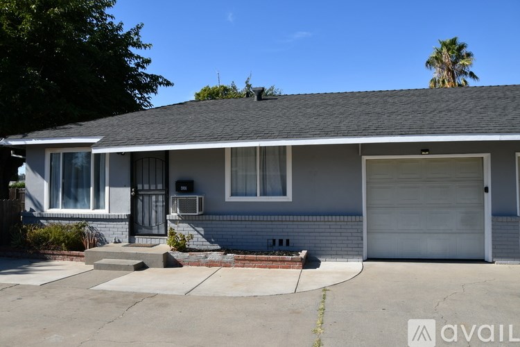 A house with a grey roof and a white garage door.