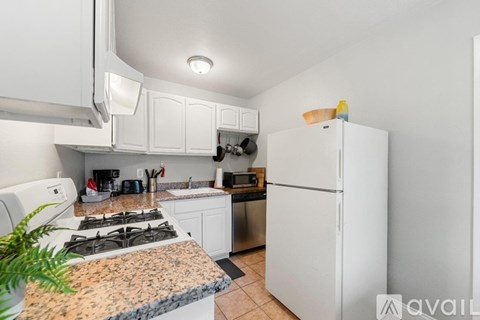 A kitchen with a granite countertop and white appliances.