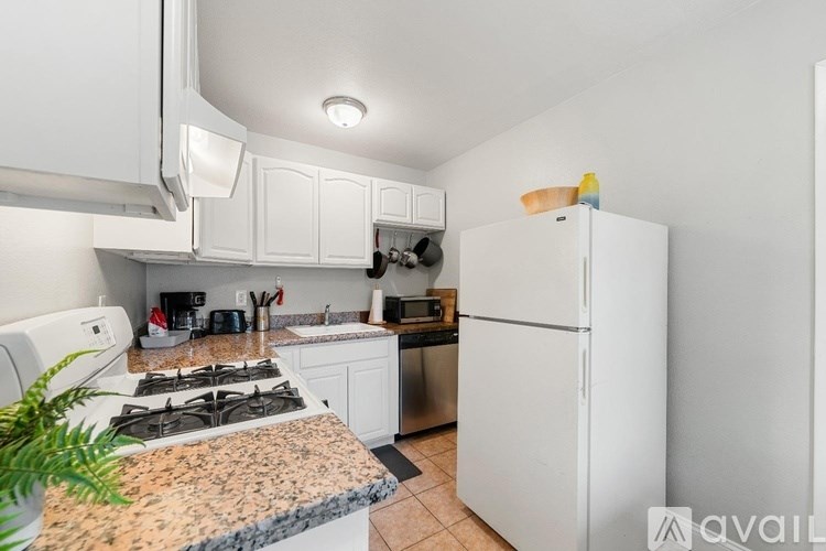 A kitchen with a granite countertop and white appliances.