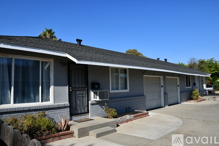 A house with a grey roof and a car parked in the driveway.