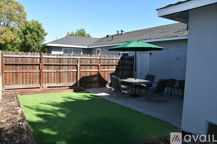 A backyard with a green lawn and a wooden fence.