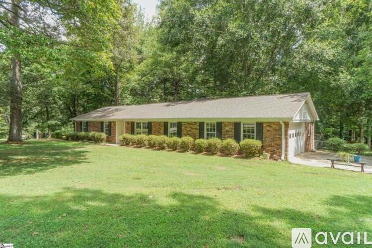 A house with a green lawn and trees in the background.