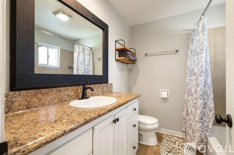 A bathroom with a sink, toilet, and shower.