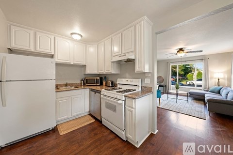 A kitchen with white appliances and cabinets.