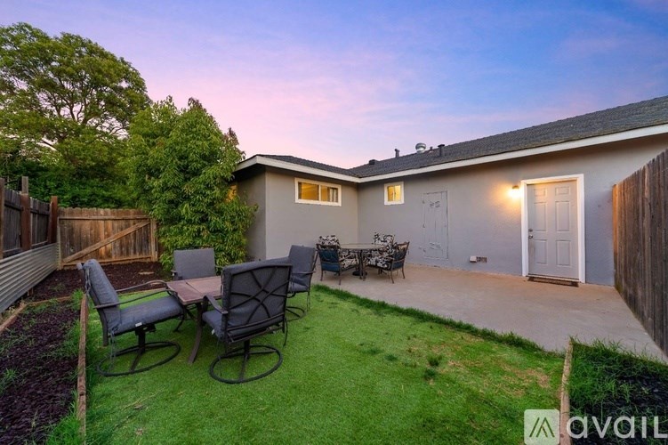 A backyard with a table and chairs set up.