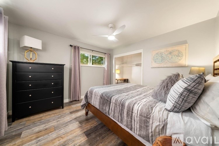 A bedroom with a bed, dresser, and mirror.