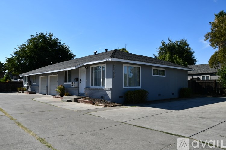 A house with a grey roof and a white door is available for rent.