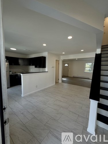A spacious, well-lit living area with a kitchen in the background.