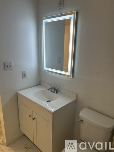 A bathroom with a sink, mirror, and toilet.